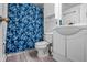 Traditional bathroom with white fixtures, floral shower curtain, and wood-look flooring at 5811 Simmul Cir, Indianapolis, IN 46221