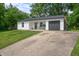 Charming single-story home featuring white siding, a gray garage door, and a well-manicured front lawn at 5811 Simmul Cir, Indianapolis, IN 46221