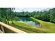 A scenic backyard featuring a serene pond, lush lawn, and a charming wooden fence at 600 Old Moore Rd, Martinsville, IN 46151