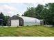 Exterior of a metal and stone outbuilding surrounded by a lush green lawn, and small landscaping at 600 Old Moore Rd, Martinsville, IN 46151
