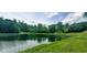 Calm pond reflecting the sky, bordered by green grass, with wooden dock in background at 600 Old Moore Rd, Martinsville, IN 46151