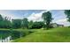 Scenic view of a pond reflecting the sky, surrounded by lush greenery, and a house on a grassy hill at 600 Old Moore Rd, Martinsville, IN 46151