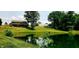 Scenic view of pond reflecting lush landscape with mature trees, with home in distance and greenhouse at 600 Old Moore Rd, Martinsville, IN 46151