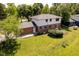 Aerial view of this home shows a brick and siding exterior, a large, open backyard, and mature trees at 6146 Rucker Rd, Indianapolis, IN 46220