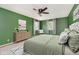 Spacious bedroom is painted green and has a light wood dresser and windows with curtains at 6146 Rucker Rd, Indianapolis, IN 46220
