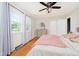 Light and airy bedroom featuring two windows with white curtains, hardwood flooring, and ceiling fan at 6146 Rucker Rd, Indianapolis, IN 46220