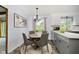Cozy eat-in kitchen with gray cabinets, tile flooring, and modern lighting fixture at 6146 Rucker Rd, Indianapolis, IN 46220