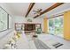 Spacious living room features a brick fireplace, beamed ceiling, and sliding glass doors at 6146 Rucker Rd, Indianapolis, IN 46220