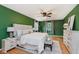 Bright main bedroom featuring neutral decor, a tufted headboard, ceiling fan and hardwood flooring at 6146 Rucker Rd, Indianapolis, IN 46220