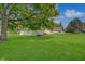 Expansive backyard featuring lush greenery, multiple structures, and large trees at 616 S Fuller Dr, Indianapolis, IN 46241