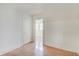 Bright bedroom featuring hardwood floors, white walls, and a glimpse into an adjoining room at 616 S Fuller Dr, Indianapolis, IN 46241