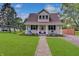Charming home featuring a lush lawn, landscaped flower beds, and a welcoming front porch with rocking chairs at 616 S Fuller Dr, Indianapolis, IN 46241