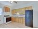 Kitchen featuring light wood cabinets, white countertops, and modern black appliances at 616 S Fuller Dr, Indianapolis, IN 46241