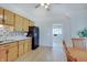 A spacious kitchen with light wood cabinets and black appliances, leading to an adjoining room at 616 S Fuller Dr, Indianapolis, IN 46241