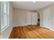 Empty bedroom showcasing gleaming hardwood floors, natural light, and closet at 6477 N Park Ave, Indianapolis, IN 46220