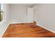 An empty bedroom has an entrance door, hardwood floors, window to the exterior, and light gray paint at 6477 N Park Ave, Indianapolis, IN 46220