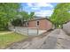 Exterior side view of a brick home with a wooden deck, driveway, and a grassy area at 6477 N Park Ave, Indianapolis, IN 46220