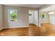 Bright, spacious living room with refinished hardwood floors and ample natural light from large windows at 6477 N Park Ave, Indianapolis, IN 46220