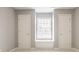 Bright bedroom featuring neutral walls, carpet, and natural light from a window between two doors at 6685 Chapel Xing, Zionsville, IN 46077