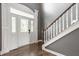 Bright foyer featuring hardwood floors, staircase with white spindles, and glass paneled front door at 6685 Chapel Xing, Zionsville, IN 46077