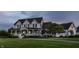 A beautiful two story white home with black shutters, a charming front porch, and a sprawling green lawn at dusk at 6685 Chapel Xing, Zionsville, IN 46077