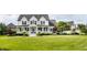 A charming two-story home features a welcoming front porch, complemented by manicured landscaping and a lush green lawn at 6685 Chapel Xing, Zionsville, IN 46077