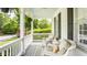 Inviting covered porch with wicker seating, decorative rug, ceiling fan and views of a lush front yard at 6685 Chapel Xing, Zionsville, IN 46077