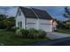 A two-car garage featuring white doors and siding complements the home's aesthetic, set amidst green lawns and shrubbery at 6685 Chapel Xing, Zionsville, IN 46077