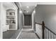Hallway with hardwood railing, carpeted floor, and built-in shelves at 6685 Chapel Xing, Zionsville, IN 46077