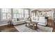 Sunlit living room with large windows, hardwood floors, neutral sofas, and a decorative rug at 6685 Chapel Xing, Zionsville, IN 46077