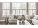 Bright living room featuring large windows, white plantation shutters, and comfortable seating arrangement at 6685 Chapel Xing, Zionsville, IN 46077