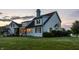 Well-maintained two-story home with a screened porch, siding, trimmed bushes, and a lush green lawn at dusk at 6685 Chapel Xing, Zionsville, IN 46077