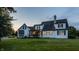 Two-story house with a screened porch and pristine lawn is showcased at dusk, highlighting the home's features at 6685 Chapel Xing, Zionsville, IN 46077