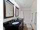 Well-lit bathroom with a double vanity, dark cabinets, and a shower-tub combo at 6927 Rose Tree Ct, Indianapolis, IN 46237