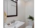 This half bathroom features a pedestal sink, decorative mirror and a toilet with a plant on top at 6927 Rose Tree Ct, Indianapolis, IN 46237