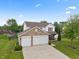 Aerial view of a two-story home with brick and siding exterior, a well-manicured lawn, and a two-car garage at 6927 Rose Tree Ct, Indianapolis, IN 46237