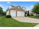 View of the home's brick-and-white siding facade, as well as an attached two-car garage and concrete driveway at 6927 Rose Tree Ct, Indianapolis, IN 46237