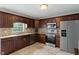 Modern kitchen with stainless steel appliances, wood cabinets, and a tiled backsplash at 6927 Rose Tree Ct, Indianapolis, IN 46237