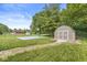Well-maintained backyard with a basketball court, storage shed, and lush green lawn at 7025 Chimney Rock Ct, Indianapolis, IN 46217
