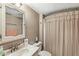 Cozy bathroom featuring a vanity with sink, toilet, shower/tub with a striped curtain, and neutral wall color at 7025 Chimney Rock Ct, Indianapolis, IN 46217