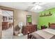Comfortable bedroom featuring a ceiling fan, neutral tones, and a view to an adjacent room with a wet bar at 7025 Chimney Rock Ct, Indianapolis, IN 46217