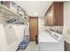 Functional laundry room with washer, dryer, overhead shelving and wooden cabinets providing ample storage at 7025 Chimney Rock Ct, Indianapolis, IN 46217