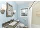 A charming blue bathroom featuring a granite vanity and shower tub at 713 W Cromer Ave, Muncie, IN 47303