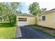 A detached yellow garage with white doors and a black driveway at 713 W Cromer Ave, Muncie, IN 47303