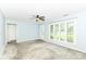 A living room with natural light, gray carpet, and a ceiling fan at 713 W Cromer Ave, Muncie, IN 47303