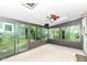 Bright sunroom with multiple windows offering views of the surrounding yard and a ceiling fan at 713 W Cromer Ave, Muncie, IN 47303