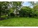 Lush green yard with mature trees and bushes offering privacy and shade at 713 W Cromer Ave, Muncie, IN 47303