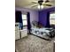 Bedroom with purple walls features plush carpet, two windows, and a comfortable bed at 719 Henry St, Lebanon, IN 46052