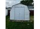 White backyard shed with double doors and shingled roof at 719 Henry St, Lebanon, IN 46052