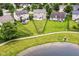 Aerial view of the home, its large manicured lawn and backyard, neighborhood park, pond, and surrounding homes at 7214 Morello Ln, Noblesville, IN 46062